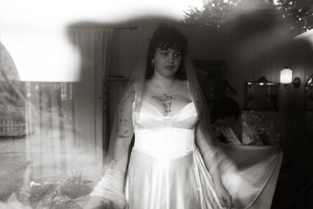 Creative black and white film portrait of bride in satin dress.