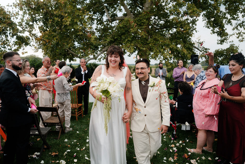 Just married couple leaving outdoor wedding ceremony in South Jersey.